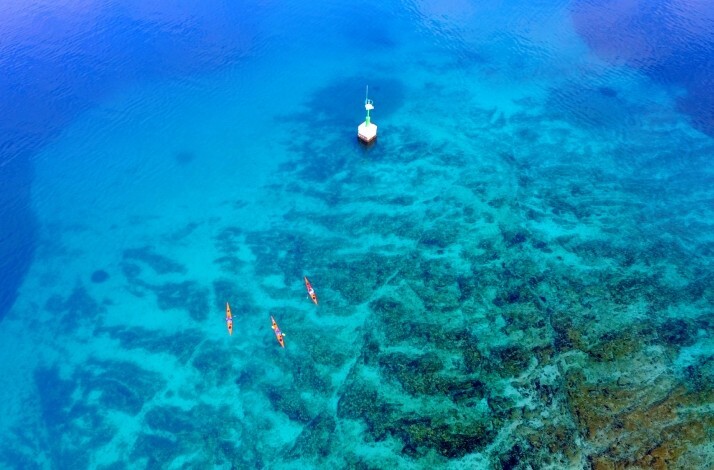 Bird's eye view at a group of tourists kayaking across Adriatic Sea on a tour of the Šibenik archipelago.